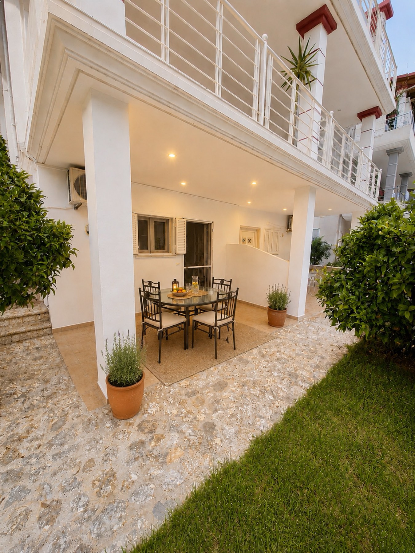 Private covered veranda framed by orange trees at Natura Garden Villas